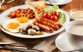 Яичница, сосиски и овощи на тарелке на завтрак
