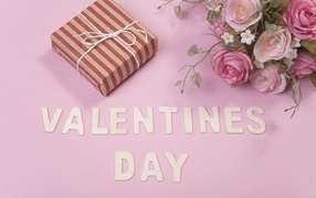 Цветы и подарок на розовом фоне на День Святого Валентина