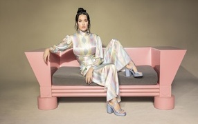 Singer Katy Perry sits on a pink sofa