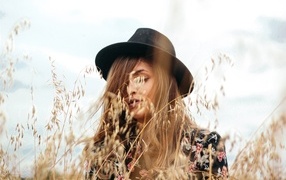 Девушка в черной шляпе в траве