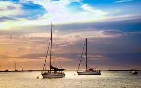 Two sailing yachts at sea at sunset
