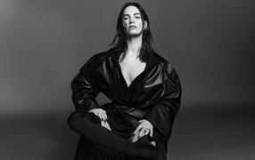 Актриса Лили Джеймс в черном наряде на сером фоне