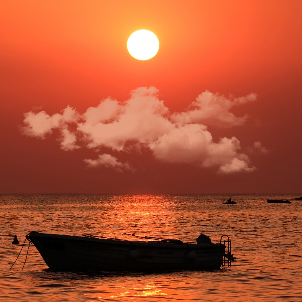 Старая лодка в воде на закате солнца