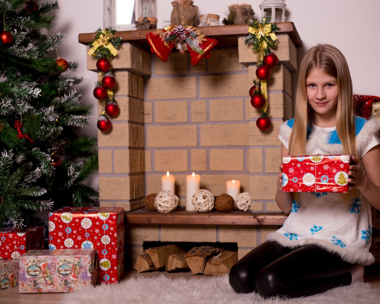 Girl sitting by the fireplace with a gift for the new year