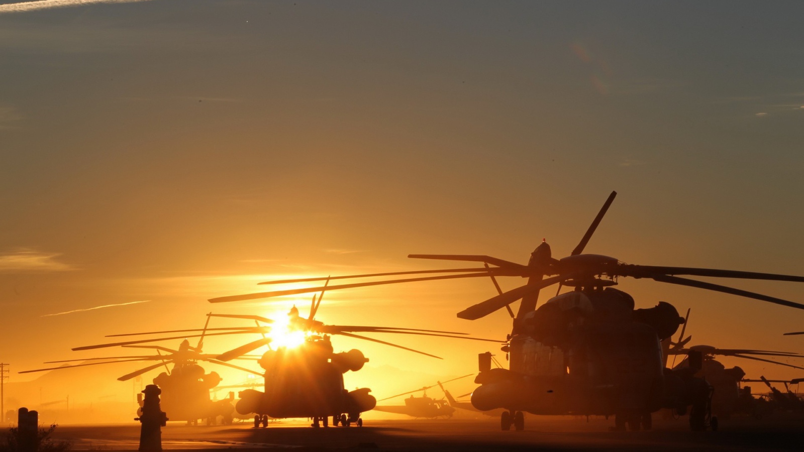Несколько вертолетов на фоне заката