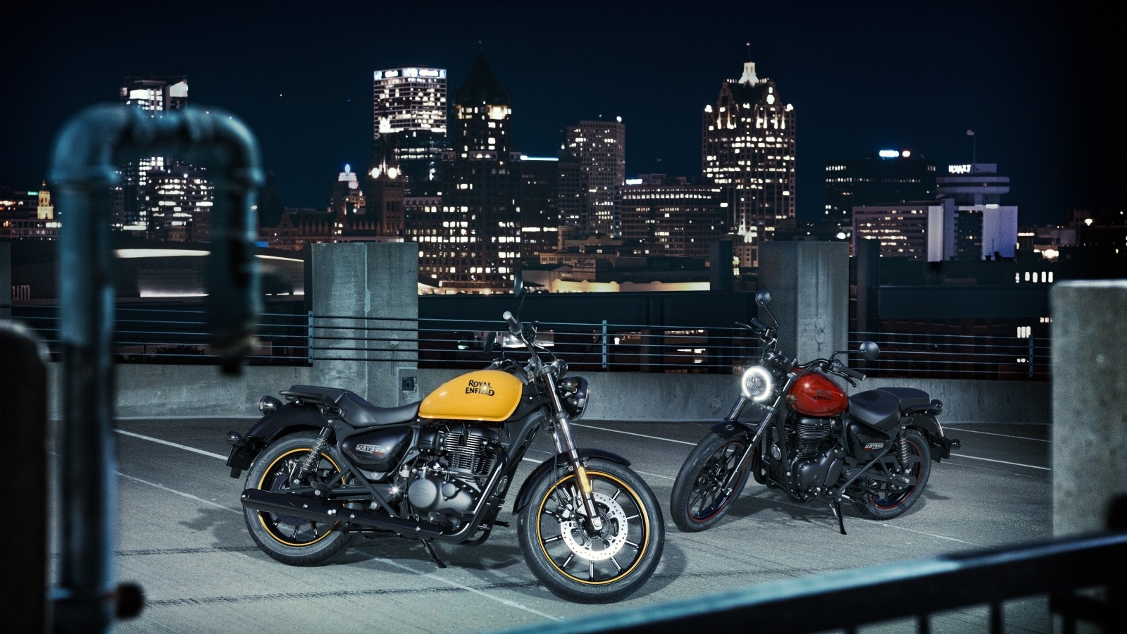 Two Royal Enfield Meteor 350 motorcycles with the city in the background