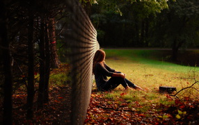 	   A girl is sitting at the fence