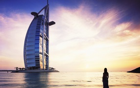 Девушка у берега моря смотрит на Бурдж-Дубаи