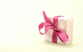 Gift box with pink bow on white background