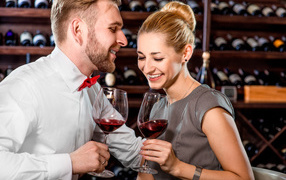 Smiling couple with glasses of wine in their hands