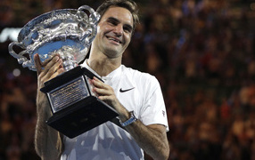 Smiling Swiss tennis player Roger Federer with a prize in his hands