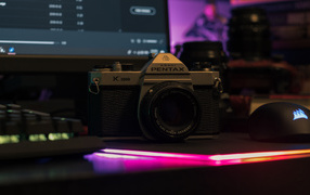 Pentax camera on the table with a computer