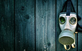 Gas mask hanging on a wooden wall, pandemic covid-19