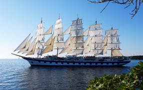 A large ship with white sails is sailing