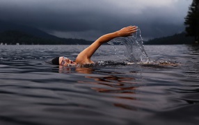 Мужчина пловец в воде озера
