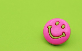 Pink smiley on green background