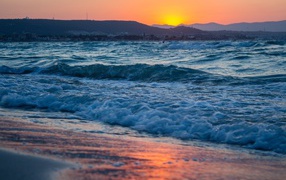 Бушующие волны на берегу моря на закате 