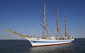 Large white sailboat with a blue stripe