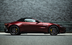 Red car Aston Martin Vantage Roadster 2023 on the background of the wall