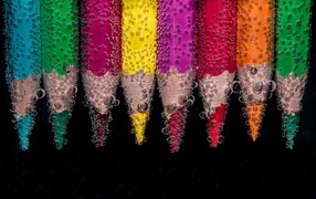 Разноцветные карандаши в пузырях воды на черном фоне