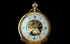 Старинные золотые карманные часы на черном фоне