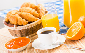 Кофе с круассанами и соком на столе на завтрак