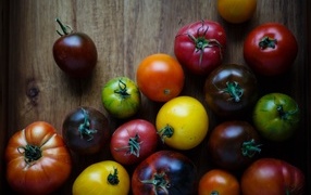 Разноцветные помидоры на деревянном столе