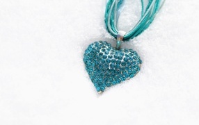 Blue pendant in the shape of a heart on the snow