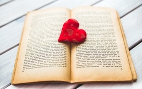 Little red heart with a book on the table
