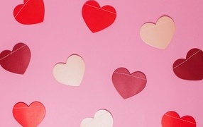 Paper multi-colored hearts on a pink background