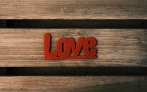 Red inscription love on a wooden background
