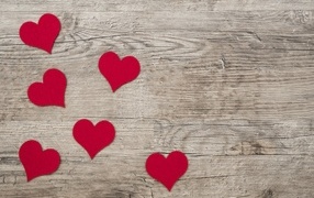 Small red hearts on wooden background