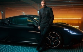Футболист Дэвид Бекхэм у черного автомобиля Maserati MC20