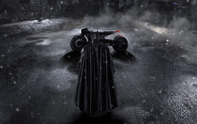 Batman in a black cloak with a motorcycle