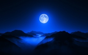Большая луна в ночном небе над горами