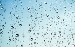 Капли дождя на голубом стекле