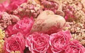 Сердце лежит на цветах розовой розы
