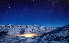 Красивое ночное небо над покрытыми снегом горами