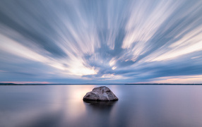 Large stone in the water under a beautiful sky