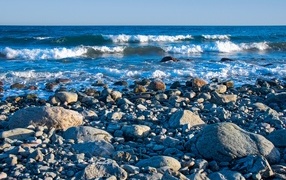 Large stones on the seashore with white waves