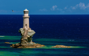 Old lighthouse on a stone island in the sea
