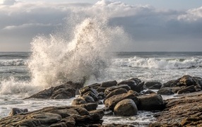Sea waves crash against the rocks on the shore