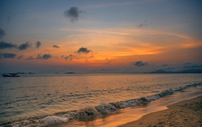 Sea waves wash the shore at sunset