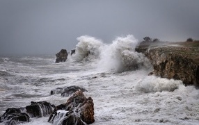 White foam waves hitting rocks during a storm