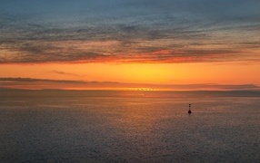 Яркий оранжевый закат на морском горизонте