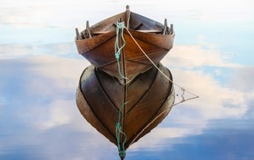 Large wooden boat reflected in the water