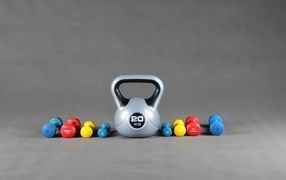Kettlebell and dumbbells on a gray background