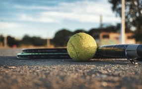 Старый теннисный мяч с ракетками