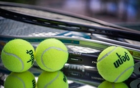 Three tennis balls with rackets