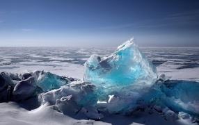 Большая голубая льдина на берегу океана